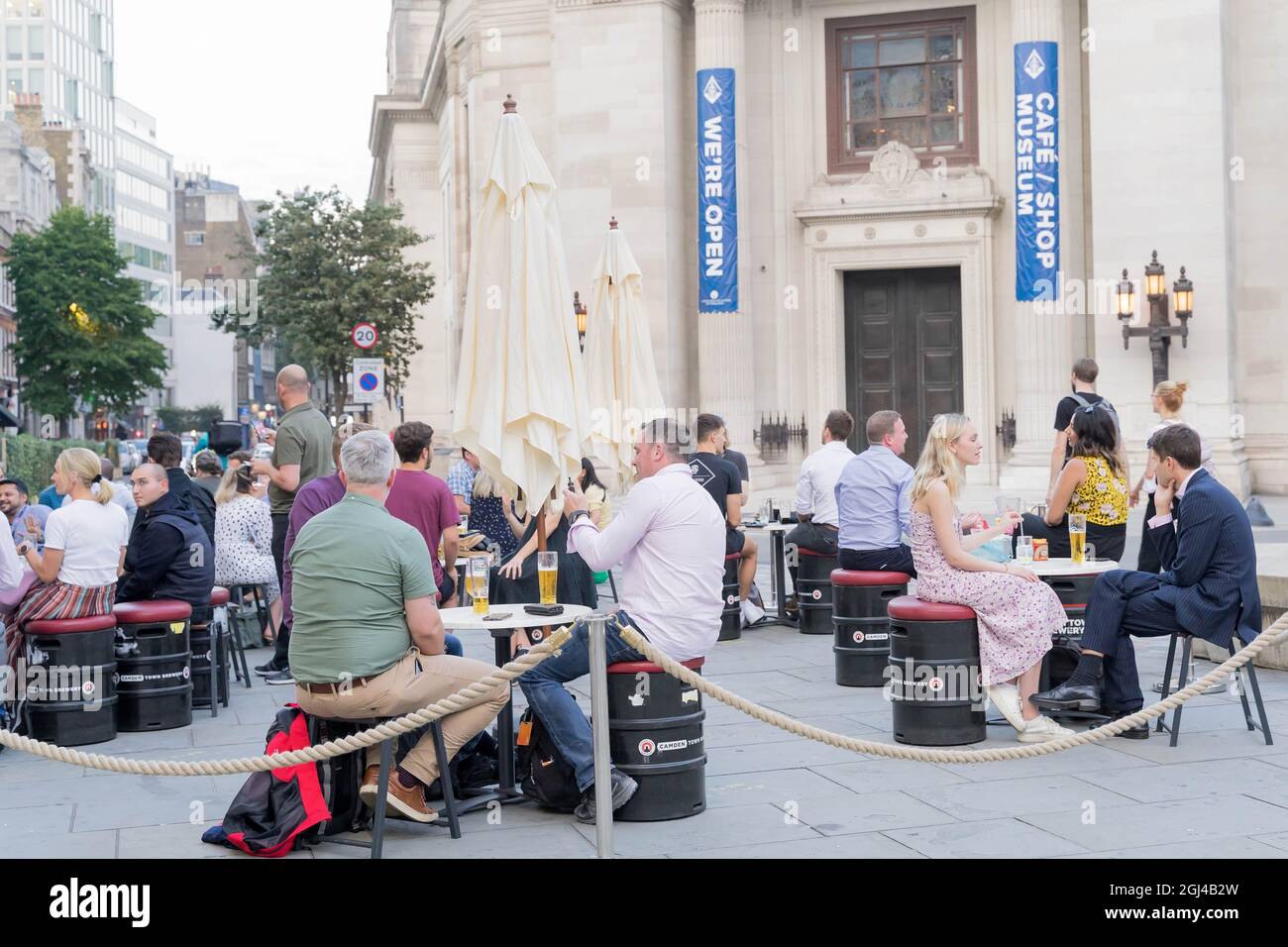 La gente gode del caldo clima autunnale in Covent Garden seduto fuori porta sul marciapiede zona salotto Londra Inghilterra Foto Stock