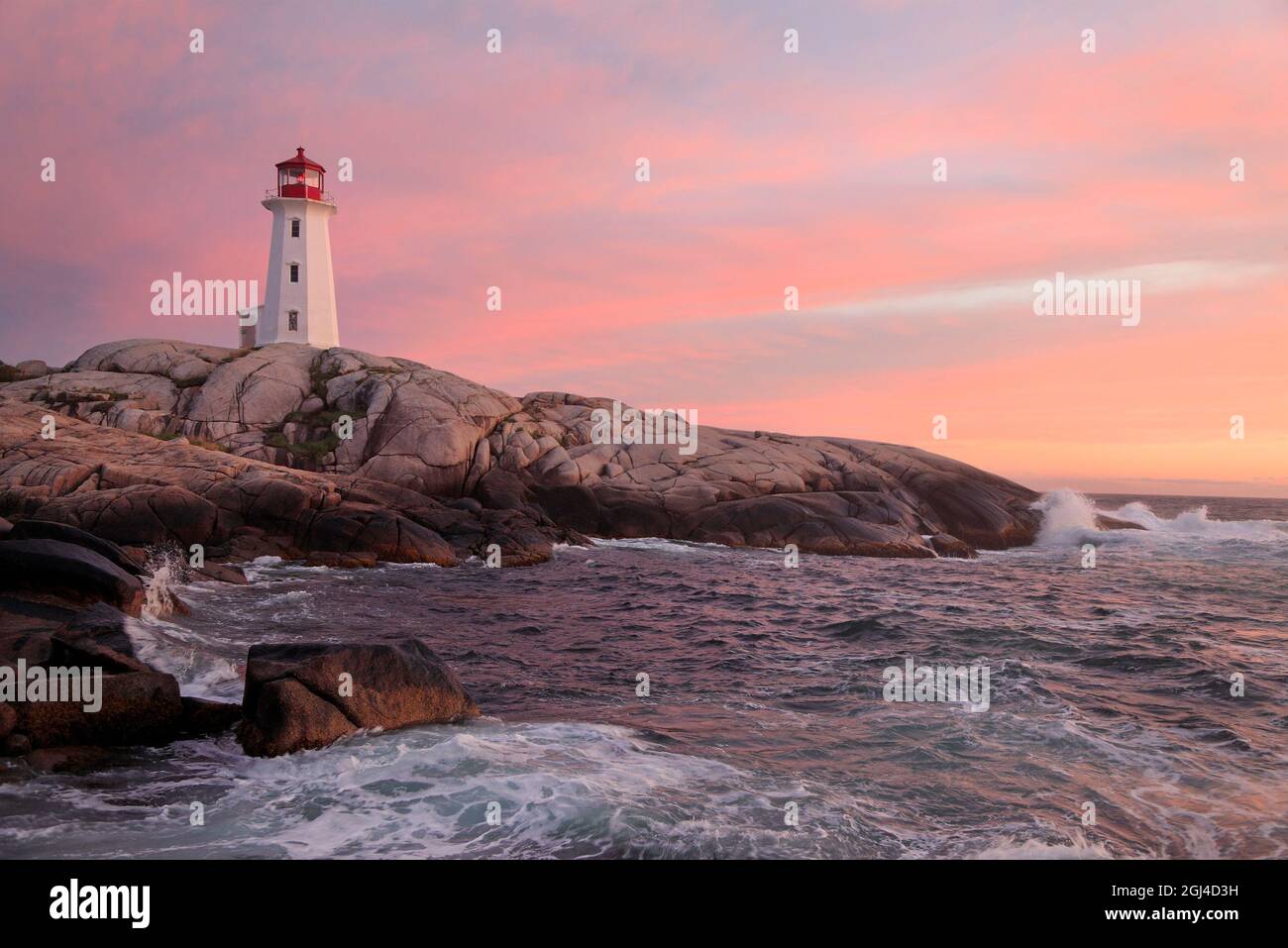 Faro di Peggy’s Cove illuminato al crepuscolo con riflessione in acqua, Nuova Scozia, Canada Foto Stock
