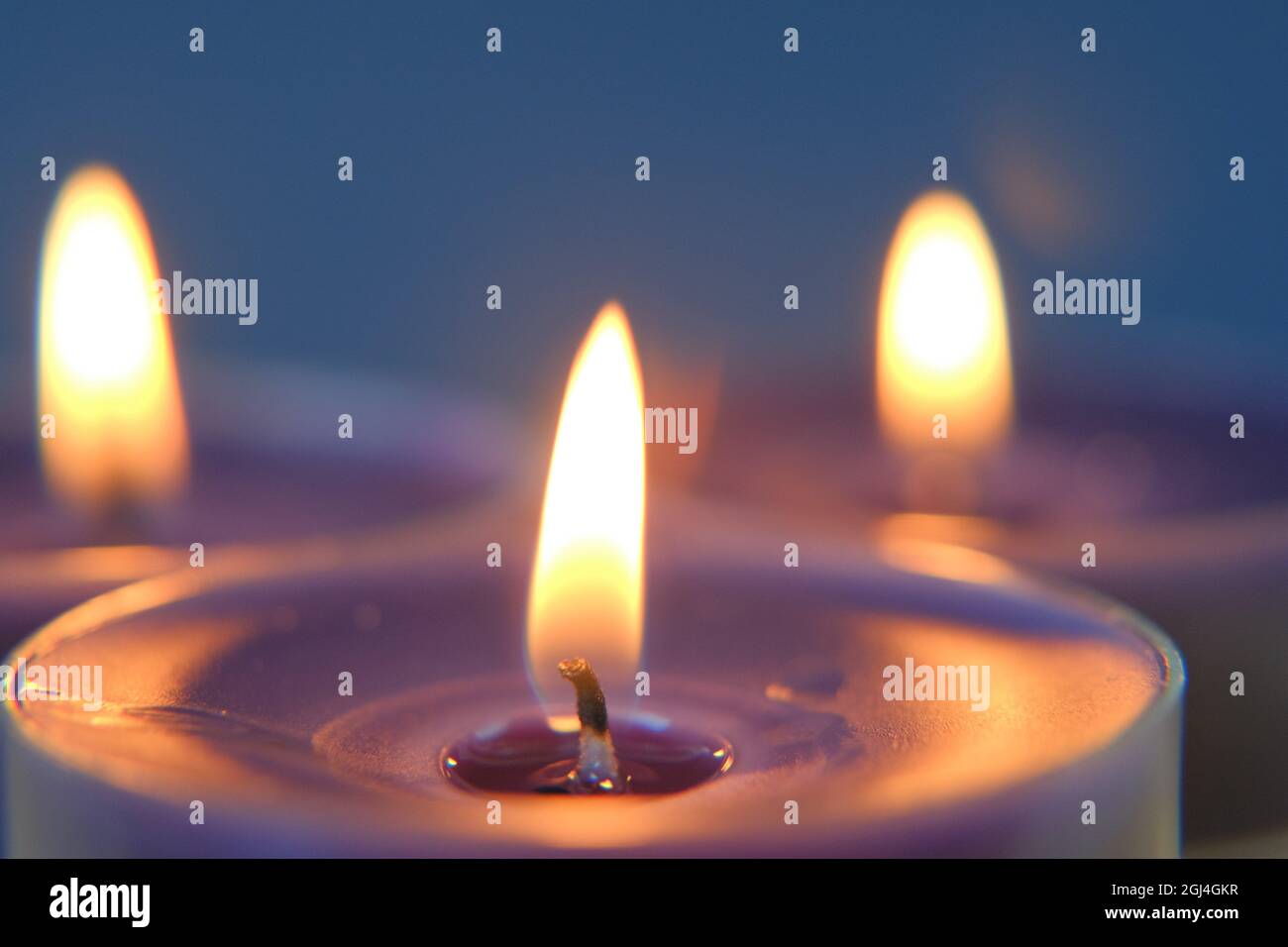 Candela che brucia la fiamma nel simbolo Dark.Religion. Candele sfondo.candele blu su sfondo blu Foto Stock