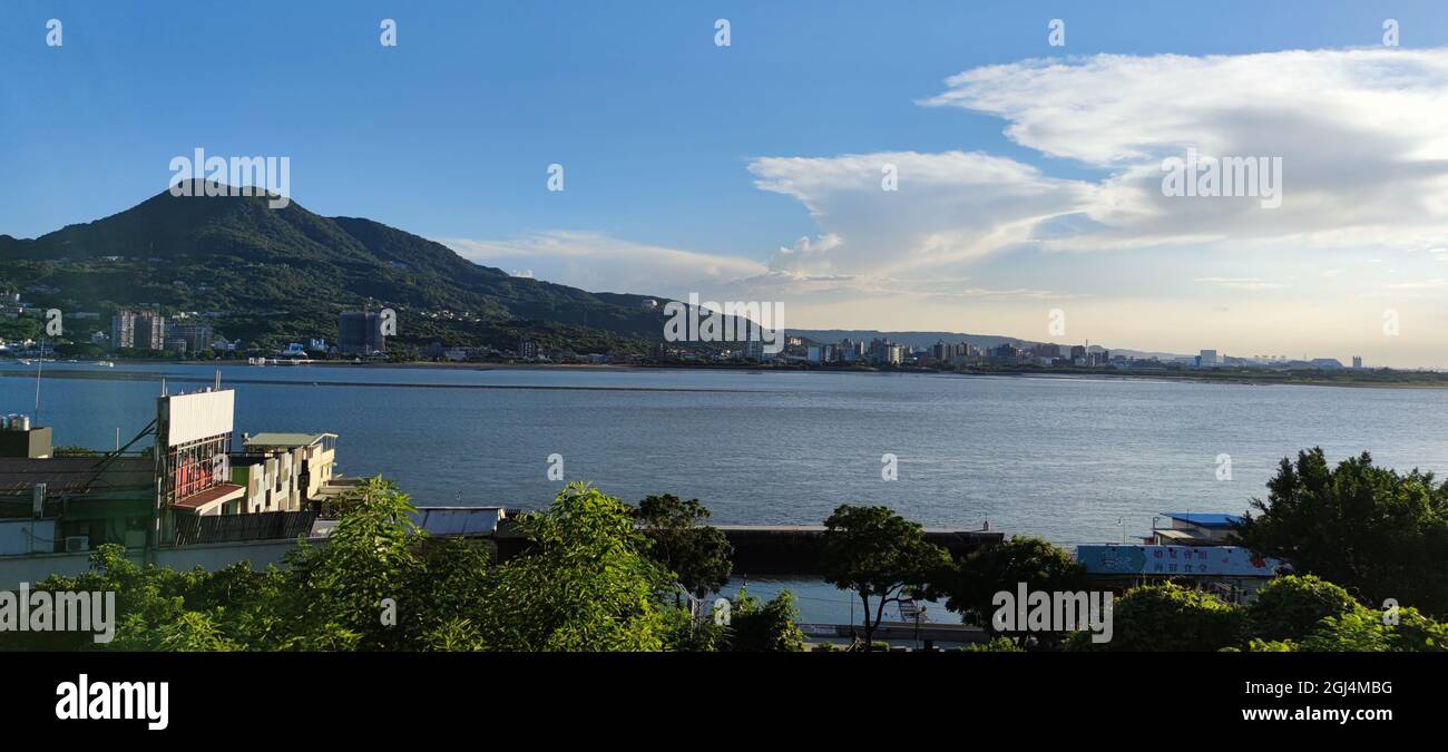 Tamsui, NUOVA CITTÀ DI TAIPEI, TAIWAN - 8 settembre 2021 - il distretto cittadino di Tamsui Bali a Taipei, Taiwan riflette nel fiume Tamsui in una bella giornata Foto Stock