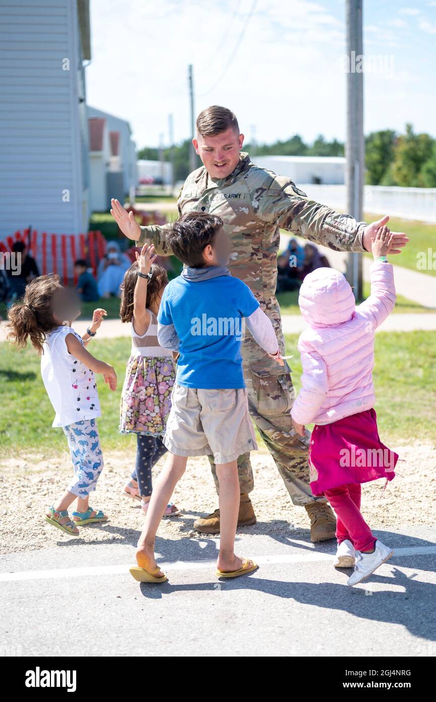 Fort McCoy, Stati Uniti. 07 settembre 2021. SPC dell'esercito degli Stati Uniti. Joe Belles, gioca con i bambini afghani evacuati da Kabul a Fort McCoy 7 settembre 2021 a Fort McCoy, Wisconsin, USA. McCoy è una delle numerose installazioni militari che forniscono alloggi temporanei agli afghani mentre vengono processati per l'immigrazione. Credito: SSgt. Ryan Rayno/US Army/Alamy Live News Foto Stock