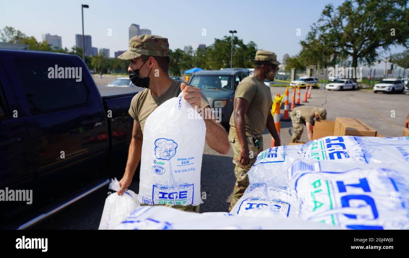 New Orleans, LA – la Guardia Nazionale della Louisiana Bravo e Charlie Companies del Louis Armstrong Park distribuiscono ghiaccio, acqua e MRE (pasti pronti da mangiare) in un centro di distribuzione drive-up ai sopravvissuti all’uragano Ida. Foto Stock