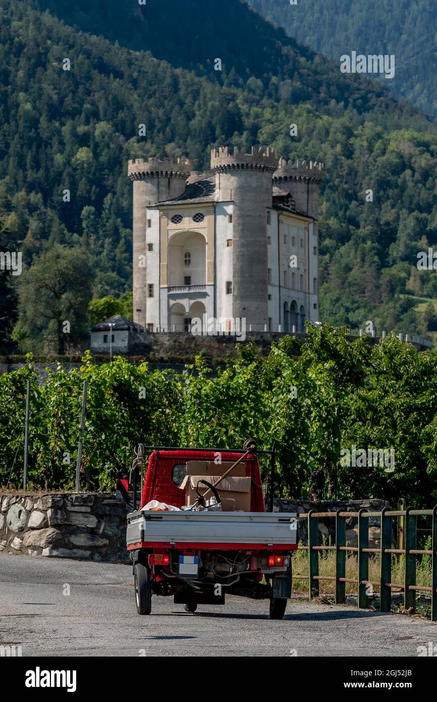 Un veicolo a tre ruote percorre una strada di campagna nei pressi del Castello di Aymavilles, Valle d'Aosta, Italia Foto Stock