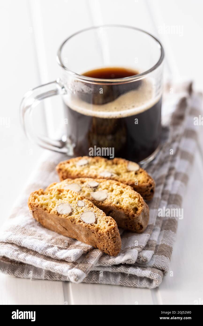 Biscotti e tazza di caffè all'italiana. Biscotti secchi dolci con mandorle su tavola bianca. Foto Stock