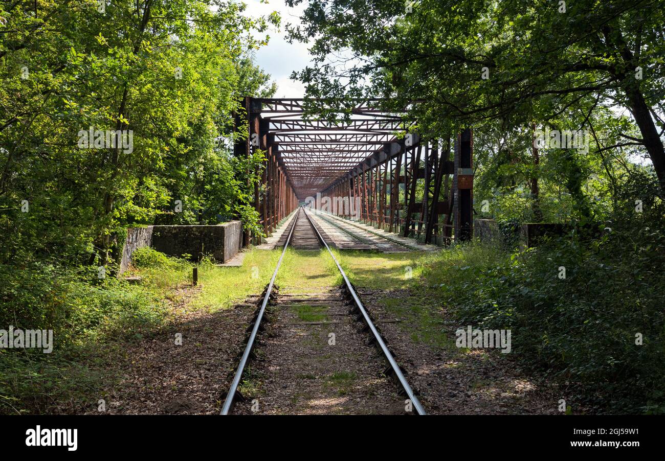 Vecchia linea ferroviaria che attraversa un ponte arrugginito trasformato in pista ricreativa per la ferrovia-ciclo draisine con quattro ruote. Foto Stock