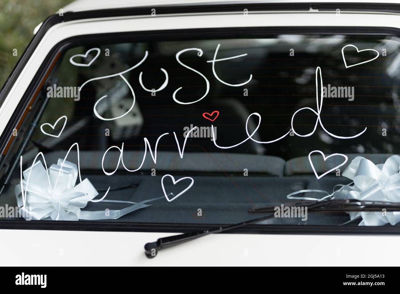Appena sposato segno scritto a mano in classico vecchio parabrezza auto con cuore d'amore per sposa e sposo dopo la cerimonia di nozze Foto Stock