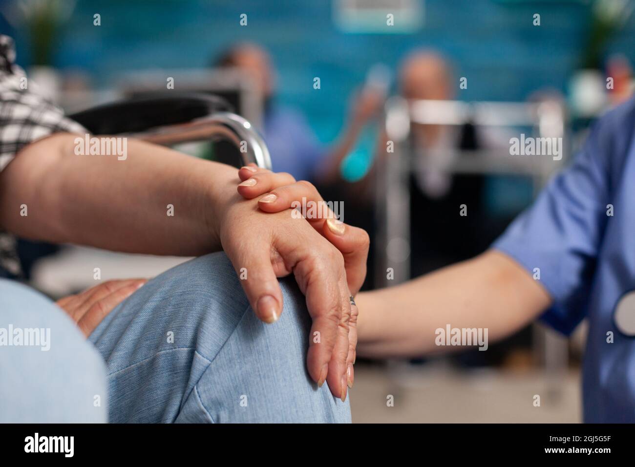 Assistente sociale che consolava il paziente handicappato che tocca le mani durante il servizio di accoglienza. Assistenza sanitaria. Servizi sociali infermieristica a casa. Infermiere Foto Stock