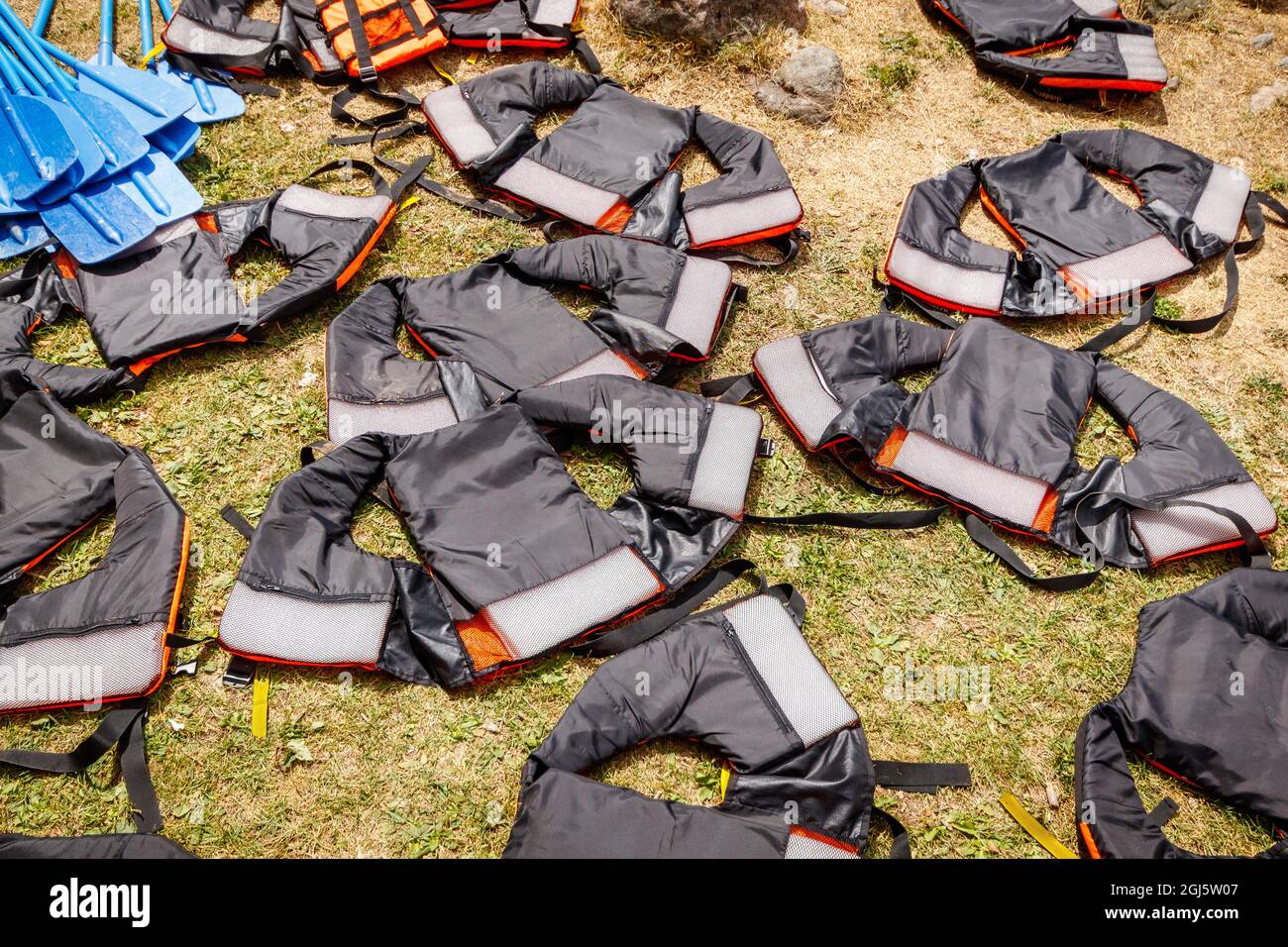Giubbotti di salvataggio asciutti sull'erba dopo il rafting. Attrezzatura di sicurezza per sport estremi. Foto Stock