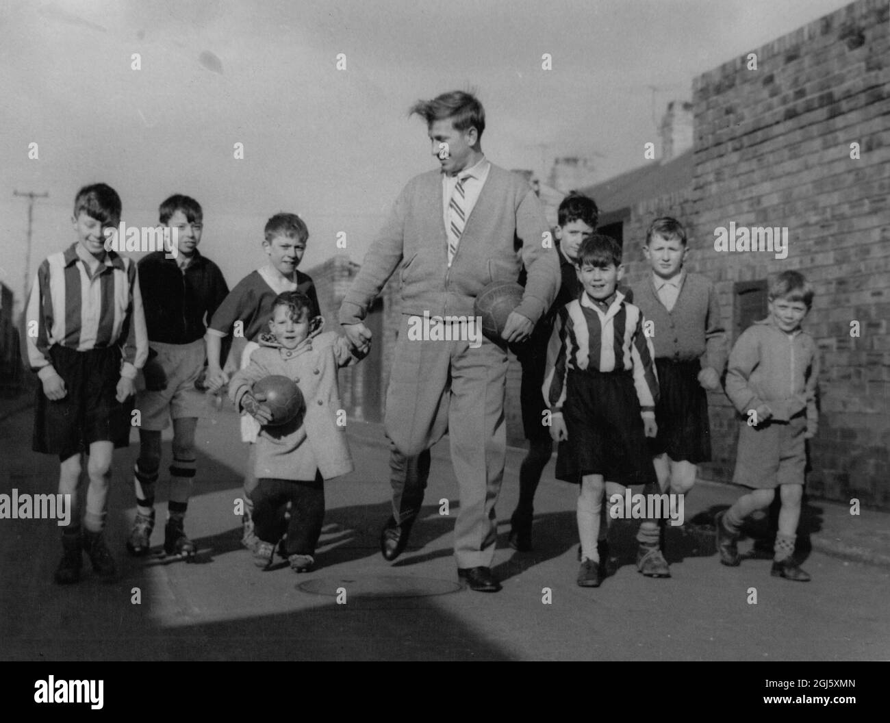 Bobby Charlton di Manchester Unito con alcuni dei kiddies locali calci una sfera nella corsia posteriore della sua sede in Beatrice Street , Ashington , Northumberland . Non denudato Foto Stock Bobby Charlton di Manchester Unito con alcuni dei kiddies locali calci una sfera nella corsia posteriore della sua sede in Beatrice Street , Ashington , Northumberland . Non denudato Foto Stock