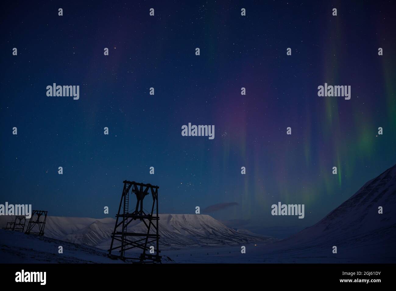 L'aurora boreale e la vecchia infrastruttura mineraria del carbone a Adventdalen, Svalbard, Norvegia. Foto Stock