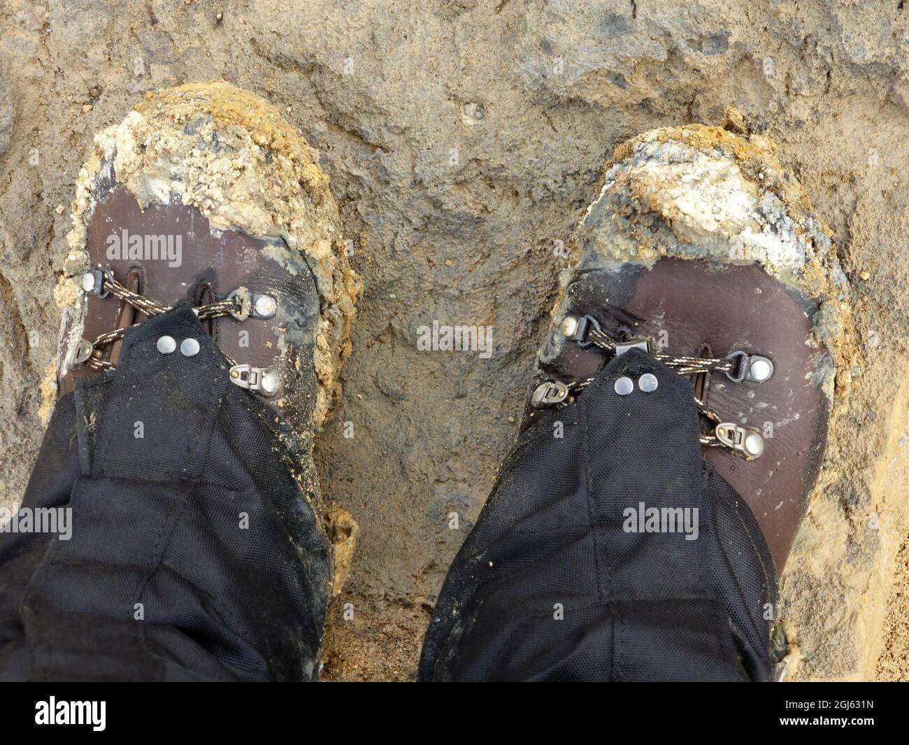 Scarponi da trekking sporchi dopo un'avventura fangosa. Stivali marroni su  argilla fangosa marrone/grigia Foto stock - Alamy