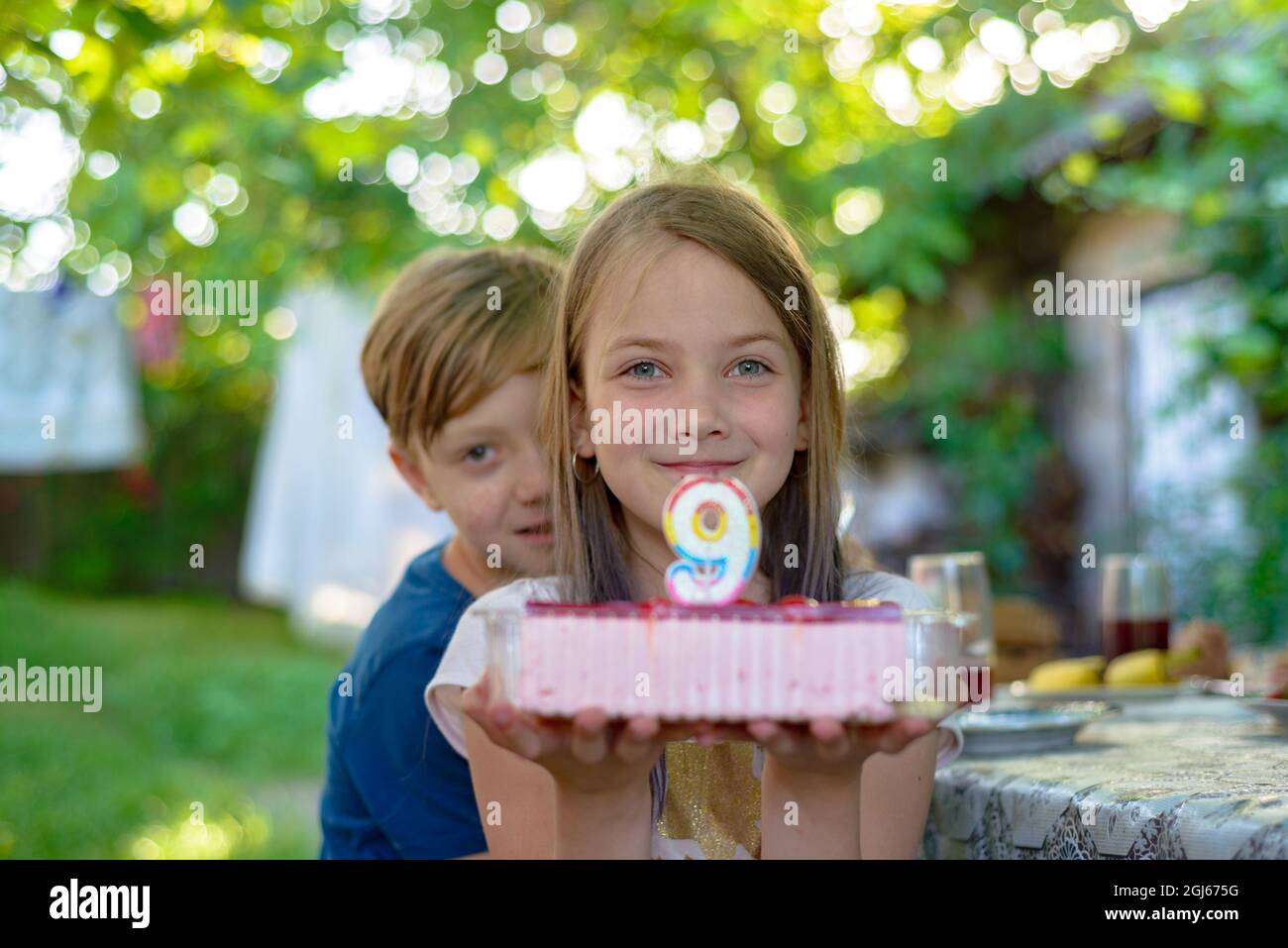 Ragazza che tiene una torta a 9 anni. Foto Stock