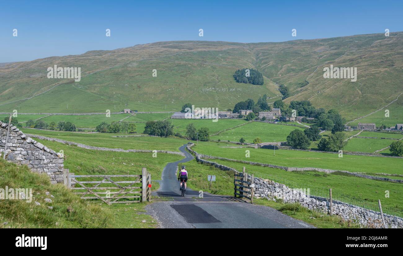 Ciclista femminile che scende a Halton Gill Road, Yorkshire Dales, Regno Unito. Foto Stock