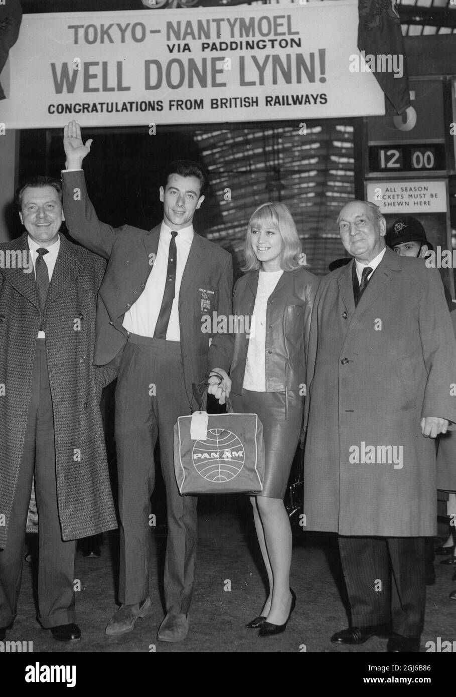 Lynn Davies - medaglia d'oro di salto lungo - ondeggiante alla folla come si trova sotto la bandiera ''ben fatto Lynn''' con la sua ragazza e due politici - 2 novembre 1964 Foto Stock