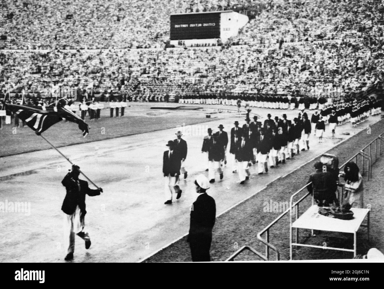 LA SQUADRA BRITANNICA IN APERTURA di 1952 GIOCHI OLIMPICI Helsinki : la squadra olimpica britannica , guidata dal portacolori Harold Whitlock , il campione olimpico del 1936 , che si è fatto strada attorno allo stadio all'apertura dei Giochi olimpici del 1952 . Oltre 6,000 atleti da 70 nazioni saranno in competizione nei Giochi . 19 luglio 1952 Foto Stock