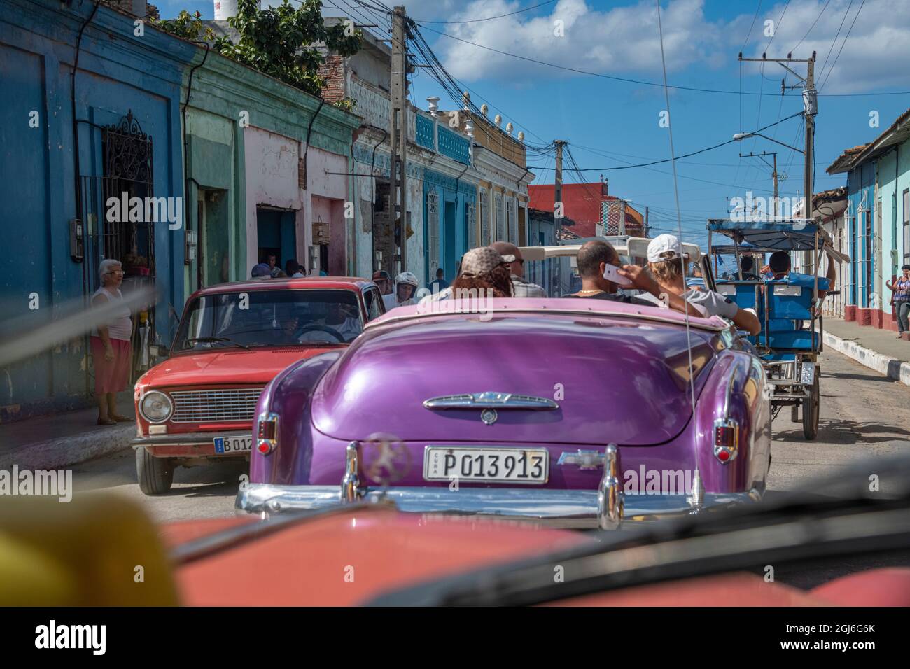 Vista dall'interno di un'auto di strada trafficata con auto viola classica americana a Trinidad, Cuba Foto Stock