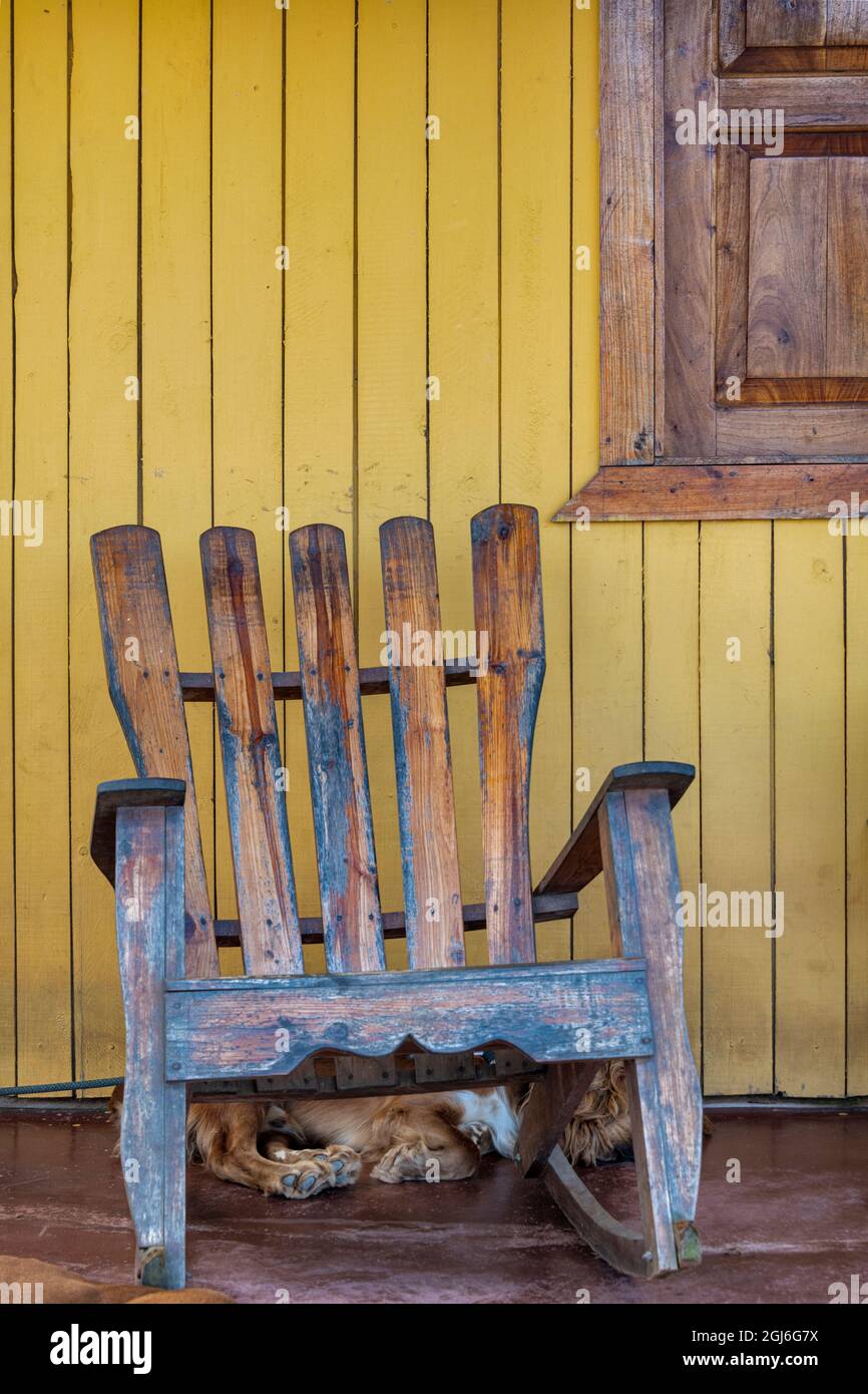 Un cane dorme sotto una sedia a dondolo di Adirondack meteo a Vinales, Cuba, Foto Stock