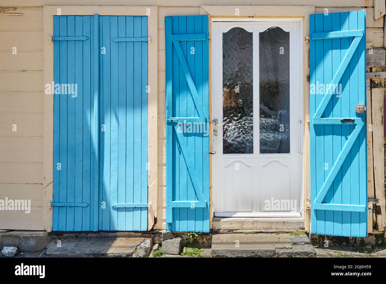Caraibi, Antille francesi, Guadalupa. Isola Marie-Galante, parte della Francia. Porta con persiane blu situato nella città (comune) di Grand-Bou Foto Stock
