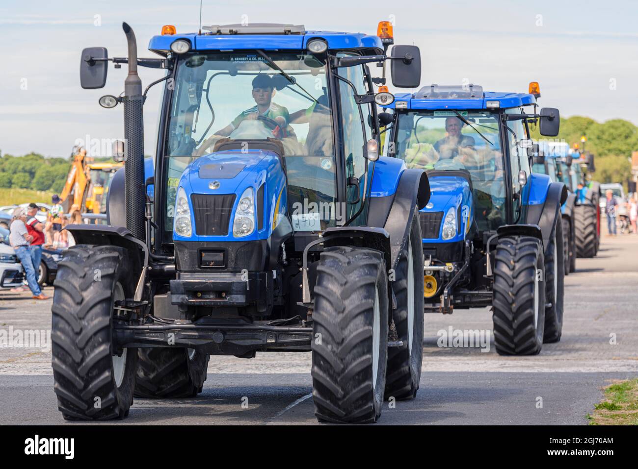Una linea di trattori blu New Holland inizia un funzionamento di trattore, comunemente detenuti nelle aree rurali dell'Irlanda per raccogliere soldi per le associazioni di beneficenza. Foto Stock