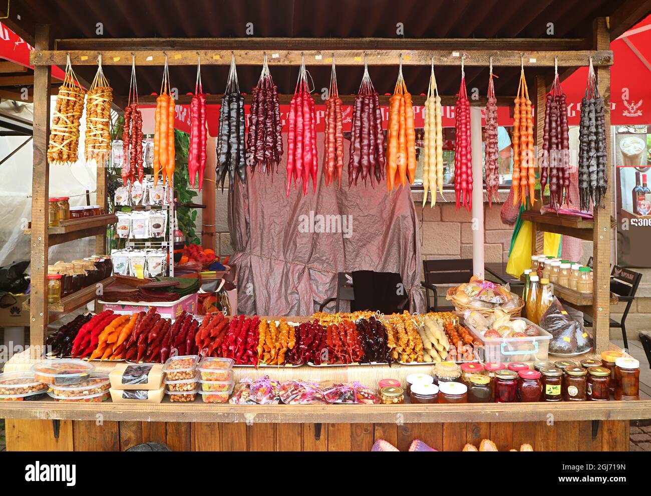 Dolci tradizionali georgiani multicolore a forma di candela chiamati Churchkhela visualizzati su una stalla Foto Stock