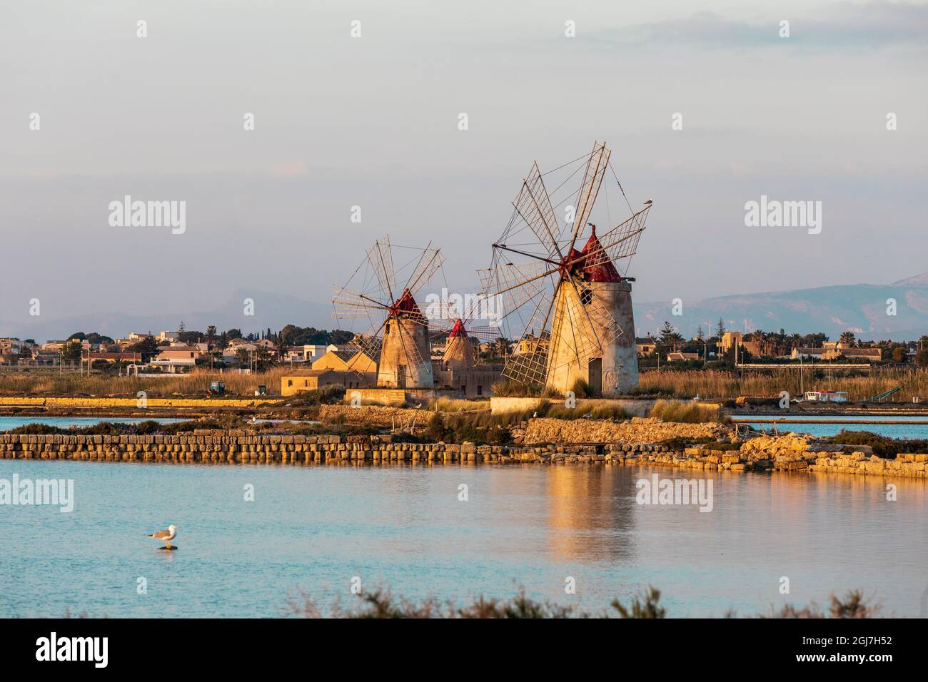 Italia, Sicilia, Provincia Di Trapani, Marsala. Mulini a vento presso gli stagni di evaporazione del sale nella Riserva Naturale dello Stagnone, a Marsala. Foto Stock