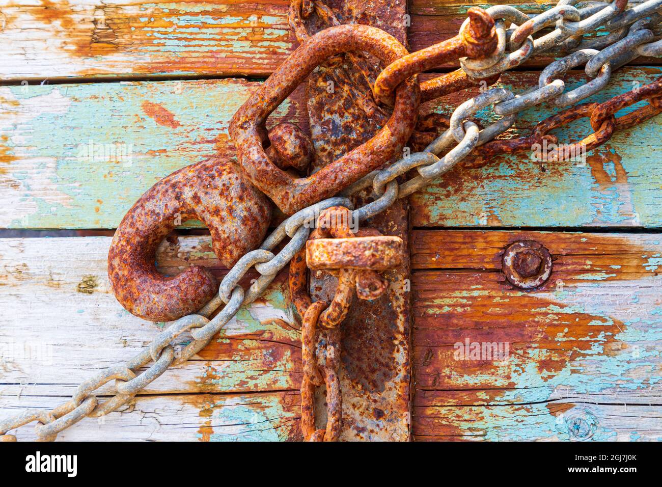 Rusty lock e la catena sul blu chiaro legno. Foto Stock