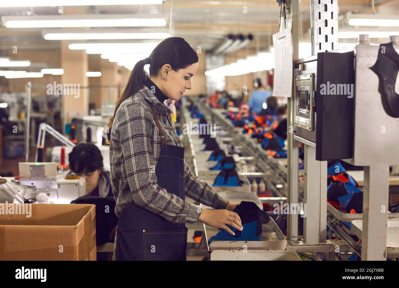 Lavoratrice femminile che produce scarpe nella linea di produzione della fabbrica di calzature Foto Stock