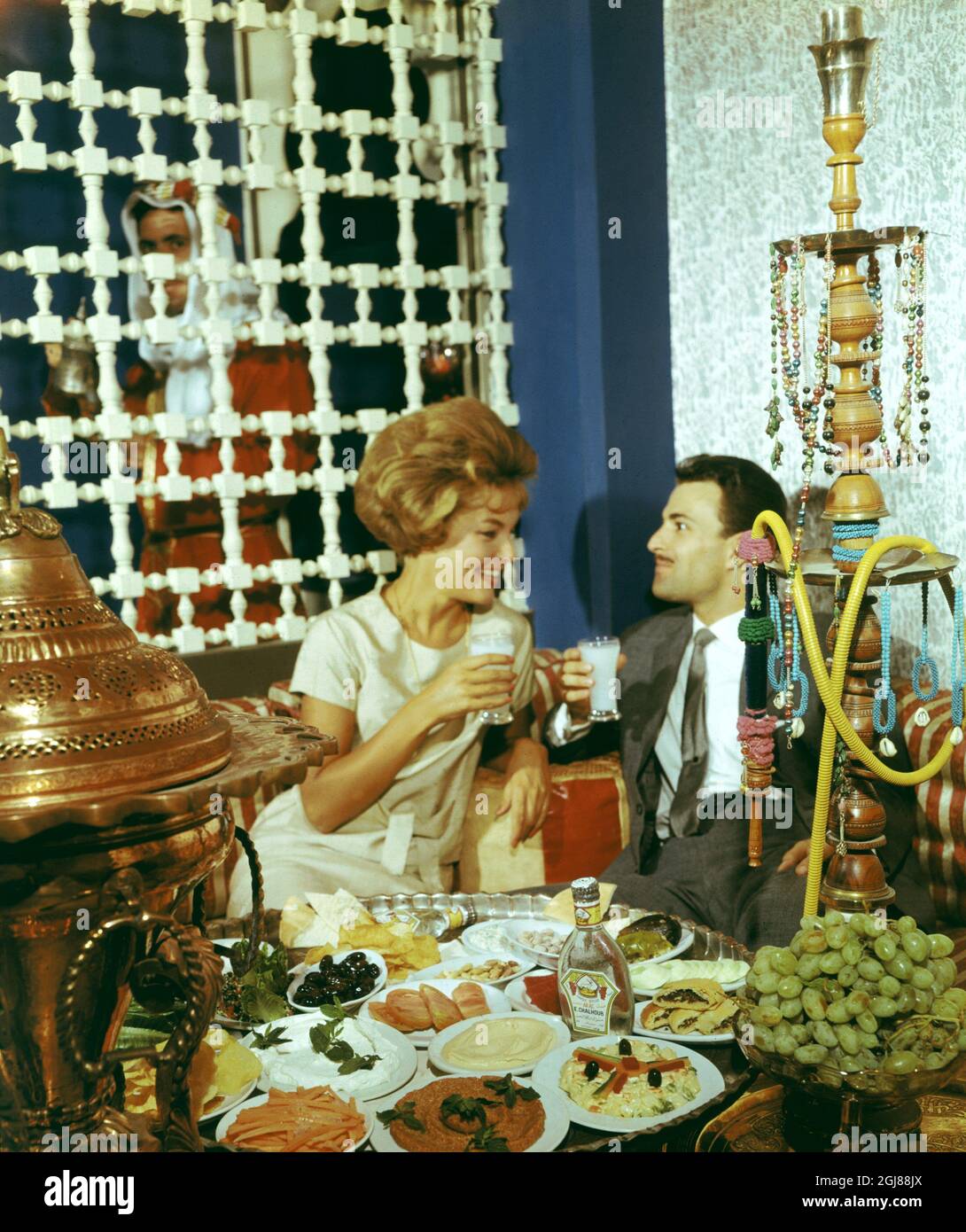 SIRIA Foto Data: 1960 -? -? LIME Una coppia si siede ad un tavolo che è  riempito di meze delicato bevendo l'arak mescolato con l'acqua all'inizio  degli anni 1960. Foto CA Peterson /