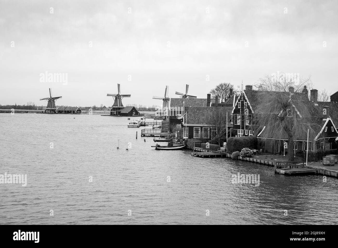 Europa, Paesi Bassi, Zaanse Schans. Case di villaggio e mulini a vento lungo il fiume Zaan. Foto Stock