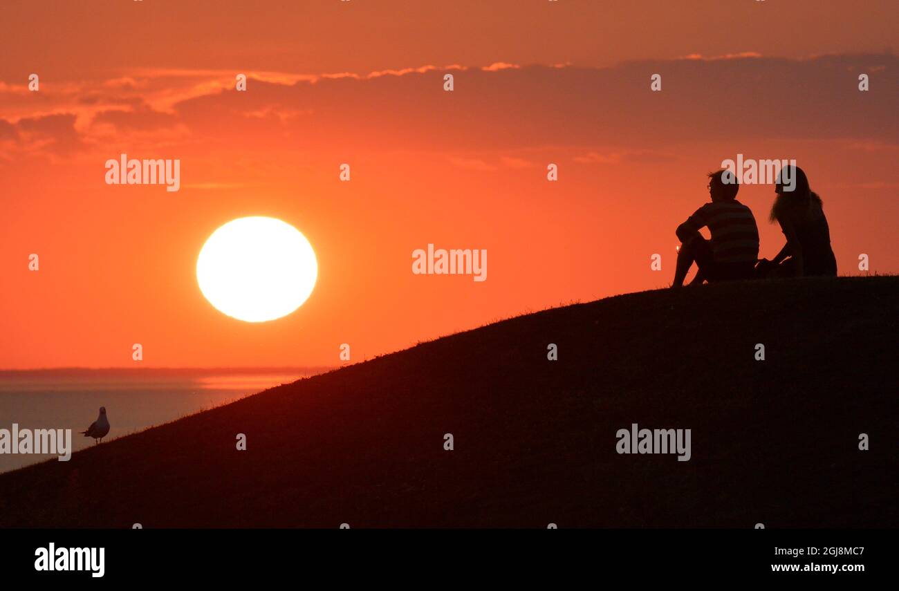 MALMO 2014-07-23 Solnedgang per mas och manniskor. Solen sanker sig i Oresund vid Scaniaparken i Malmo efter annu en varm julidag. Foto: Johan Nilsson / TT / Kod 50090 Foto Stock