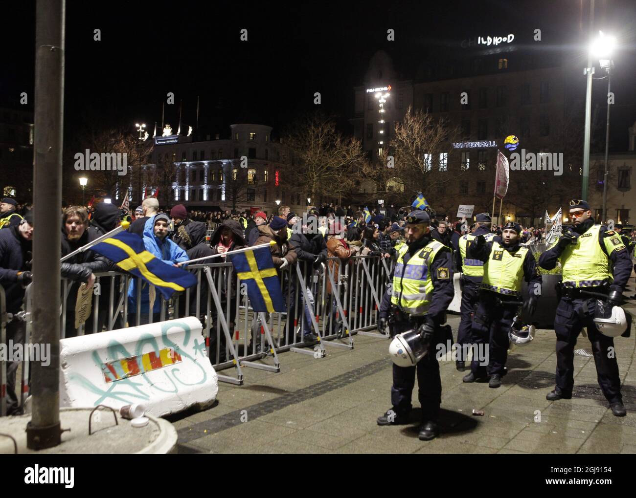 I poliziotti svedesi di sommosse sorvegliano i manifestanti PEGIDA (europei patriottici contro l'islamizzazione dell'Occidente) durante la prima manifestazione dei movimenti populisti di destra in Svezia, nella città meridionale di Malmo, il 09 febbraio 2015. Foto: Drago Prvulovic / TT / code 70040 Foto Stock