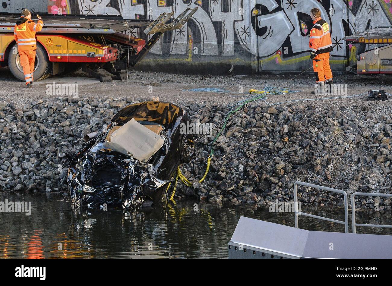 ** NUOVE INFORMAZIONI! I cinque uomini uccisi nel ponte auto crash sono stati cittadini britannici ** SODERTALJE 2016-02-13 Una macchina gravemente danneggiata è trainata dal canale sotto il ponte autostradale E4 a Sodertalje, Svezia, 13 febbraio 2016. La polizia di domenica ha confermato che i cinque uomini uccisi quando la loro auto ha attraversato il cancello e volato fuori dal ponte autostradale aperto 29 metri di altezza presto Sabato mattina sono cittadini britannici. Il ponte era stato aperto per permettere ad una nave da carico di passare sotto di esso e altre auto si erano fermate davanti al cancello e luci rosse. È in corso un'indagine sul motivo per cui la vettura in crash non è riuscita a fermarsi. Foto: Foto Stock