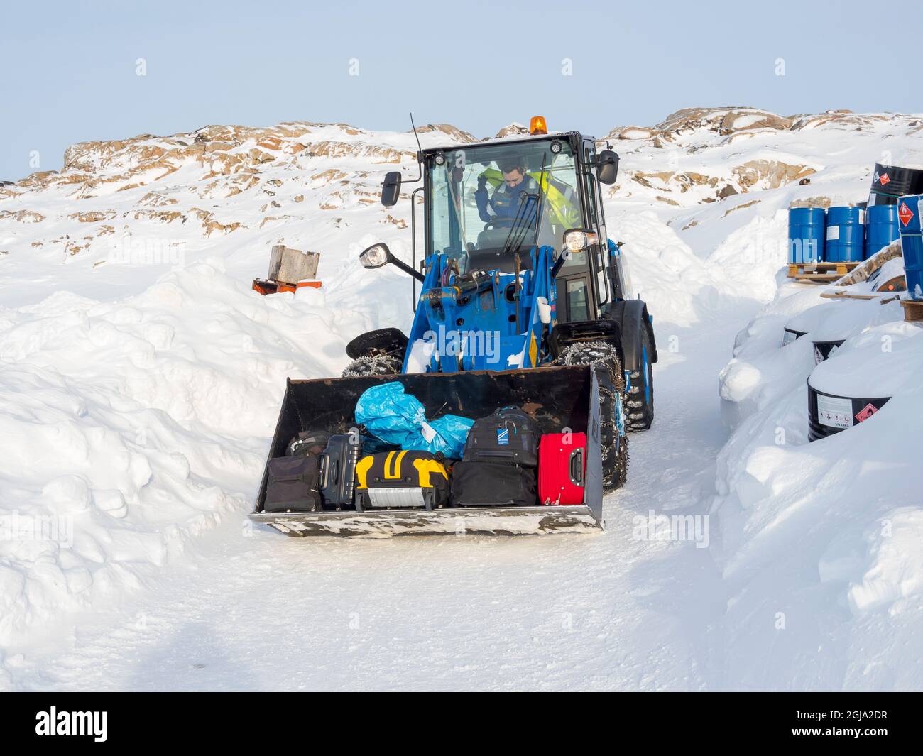 Il bagaglio viene trasportato all'eliporto. L'elicottero è l'unico collegamento con il resto della Groenlandia in inverno. Villaggio tradizionale Kullorsuaq sulla riva Foto Stock