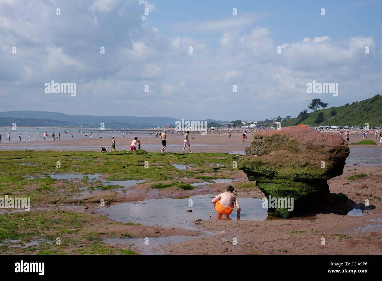 La bassa marea sulla spiaggia di Exmouth espone una zona pianeggiante di marea ricca di attività di esplorazione di pooling roccioso. Foto Stock