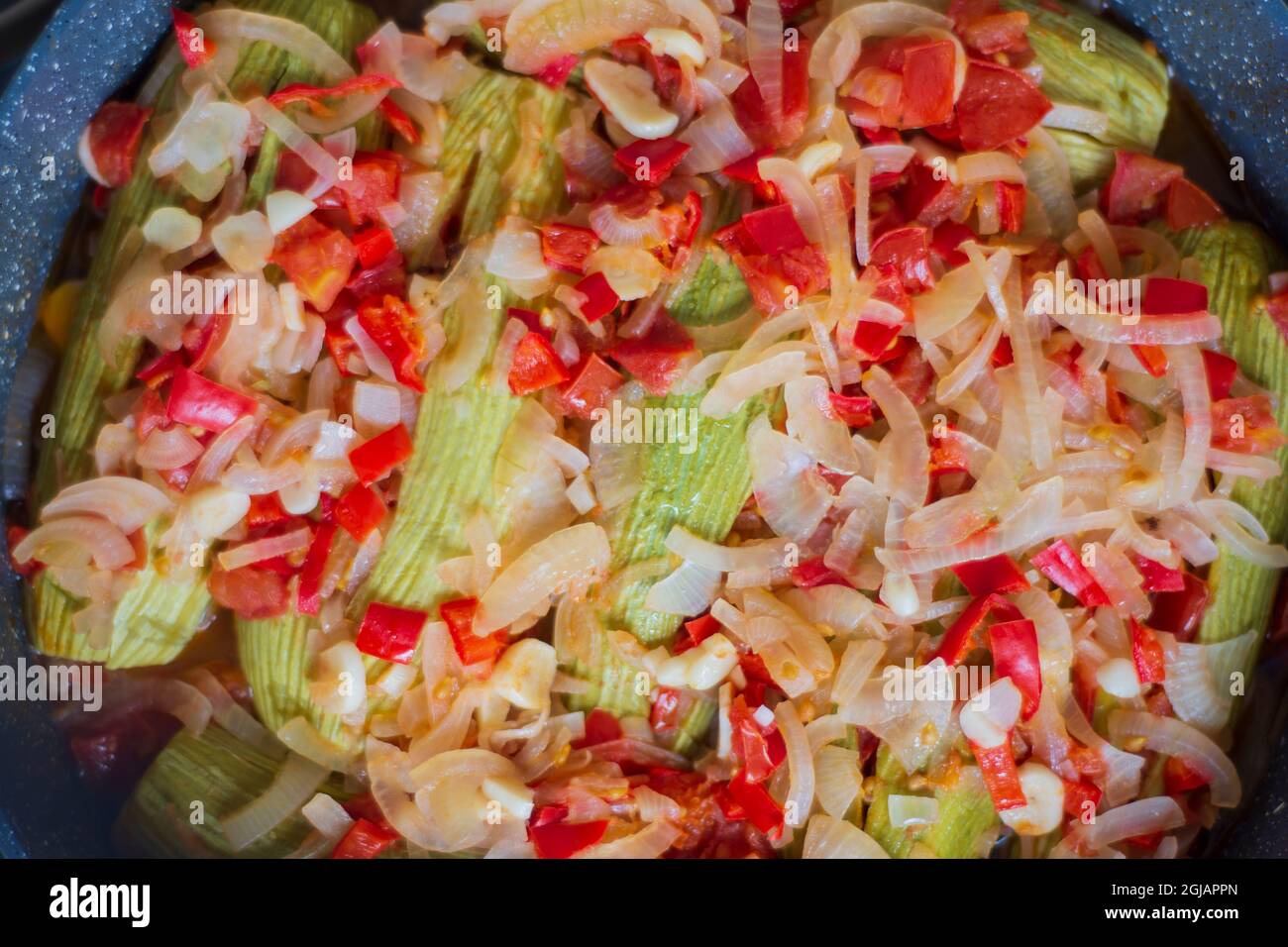Zucchine con olio d'oliva. Si cuoce con cipolle tritate finemente, peperoni e aglio. Cucina mediterranea. Foto Stock