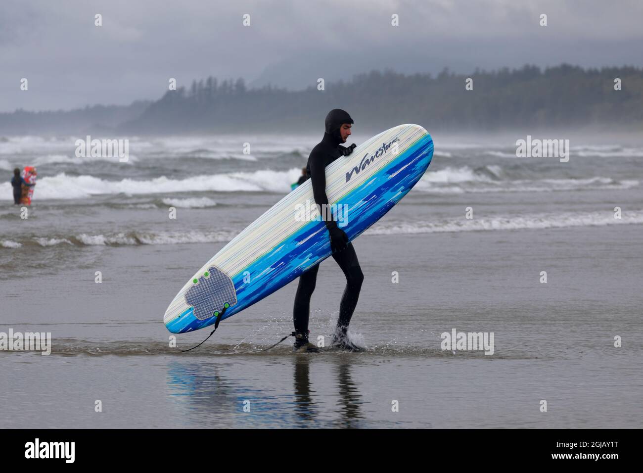Surfista d'acqua fredda sul Parco Nazionale di Wickaninnish Beach Pacific Rim, British Columbia Canada. Foto Stock