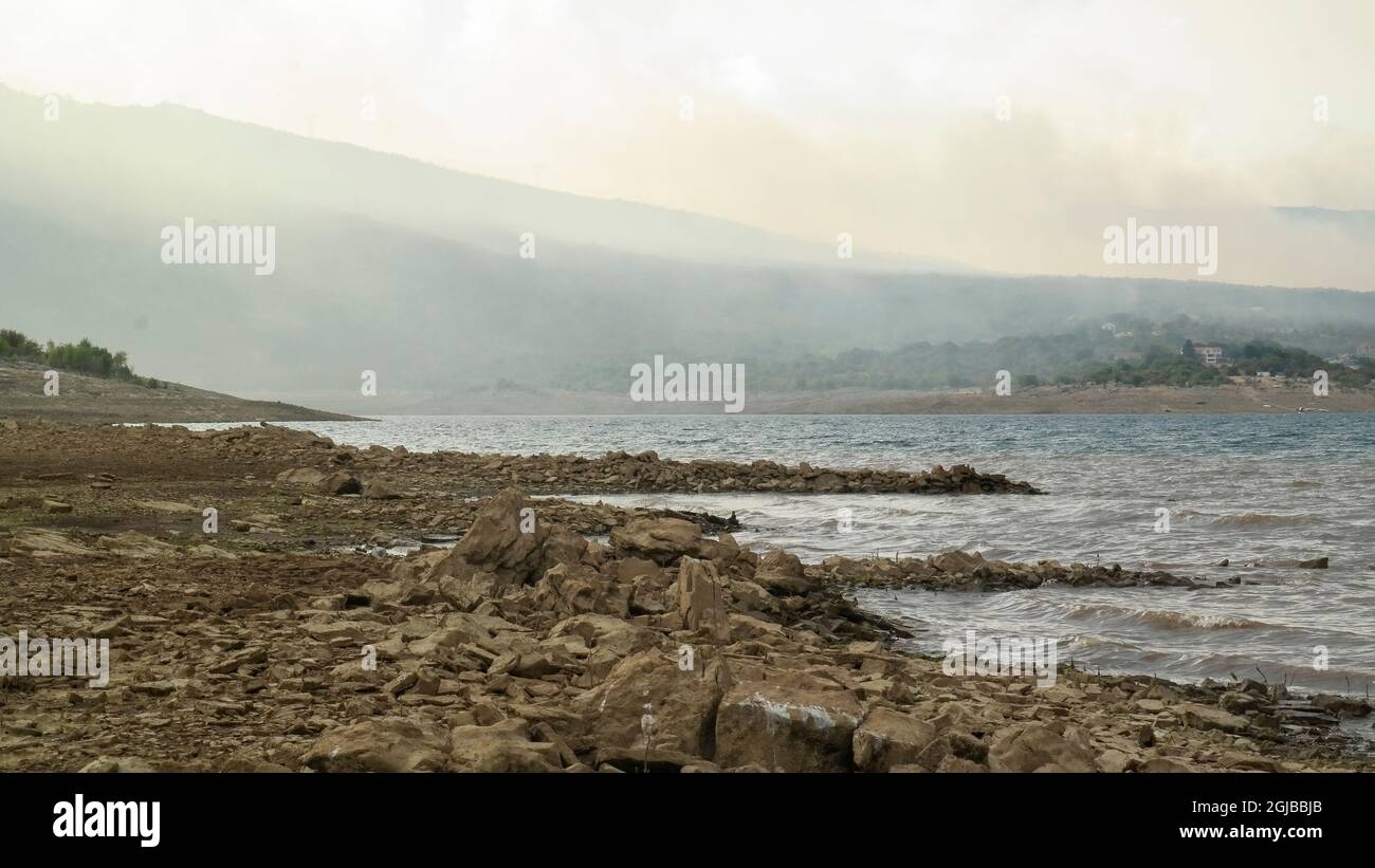 Fuoco selvaggio sulla riva del lago bileća nel villaggio deserito Panik (bileća, Bosnia-Erzegovina) Foto Stock