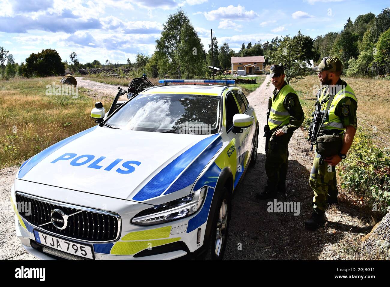 Il personale militare parla con la polizia in un'auto vicino al sito dove un JAS 39 Gripen caccia jet si schiantò fuori Ronneby, Svezia meridionale il 21 agosto 2018. L'aeroplano si schiantò dopo una collisione con un uccello. Il pilota non è danneggiato, si scontra con gli uccelli e il pilota non è danneggiato. Foto: Johan Nilsson / TT / code 50090 ** SWEDEN OUT *** Foto Stock