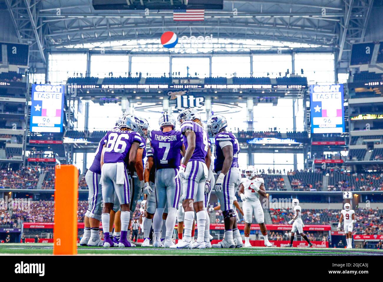 Kansas state Quarterback Skylar Thompson (7) guarda la sua playlist sul polso per chiamare un gioco nel huddle nella seconda metà di un foo NCAA college Foto Stock