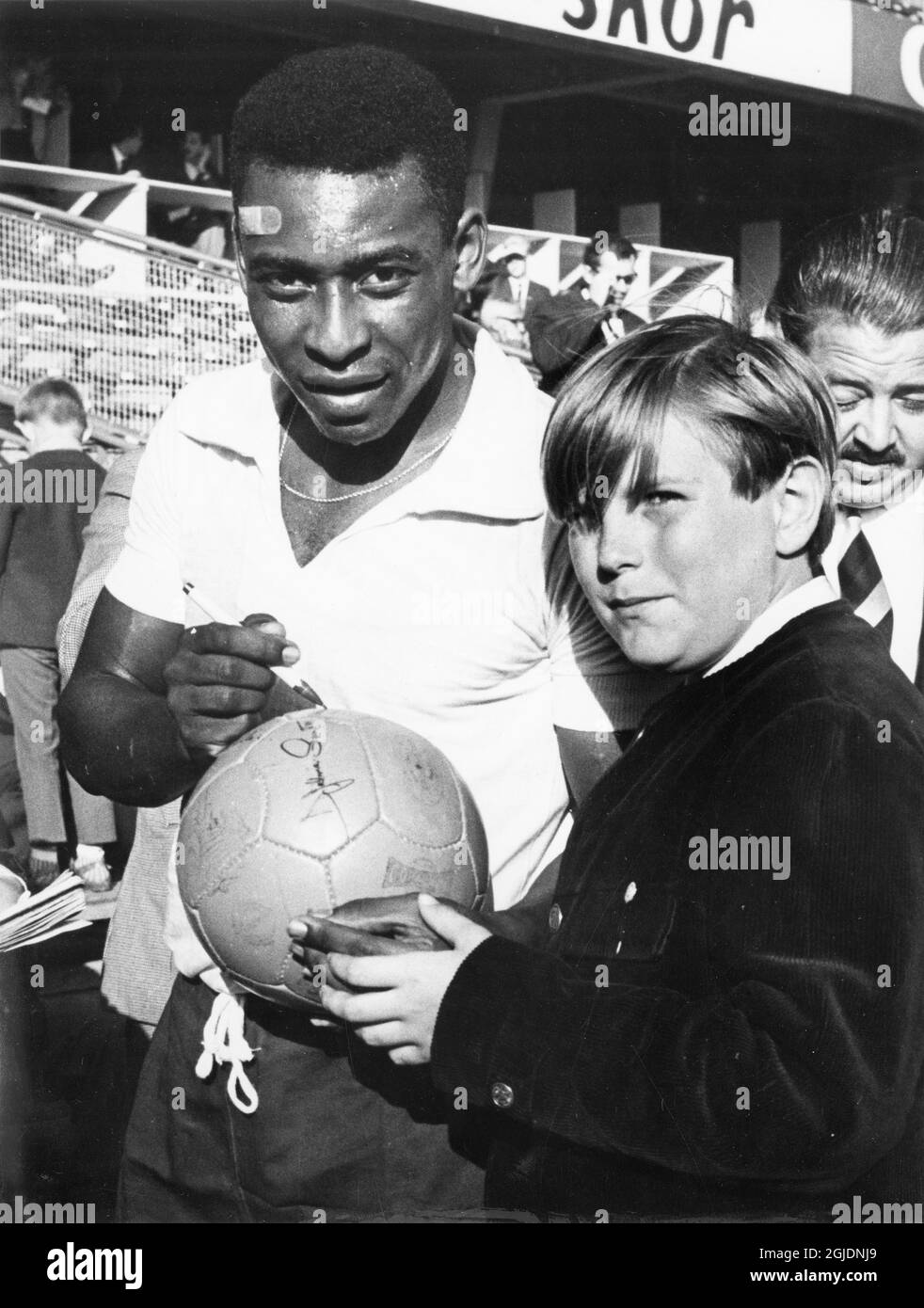 FILE STOCCOLMA 1965-06-27 Pelé del Brasile firma il suo autografo su un calcio per Stefan Engberg, un giovane fan svedese, dopo una partita amichevole tra il Brasile e il Turebergs IK allo stadio Rasunda di Stoccolma, Svezia. Foto: Freddy Lindstrom / TT / Kod: 1047 Foto Stock