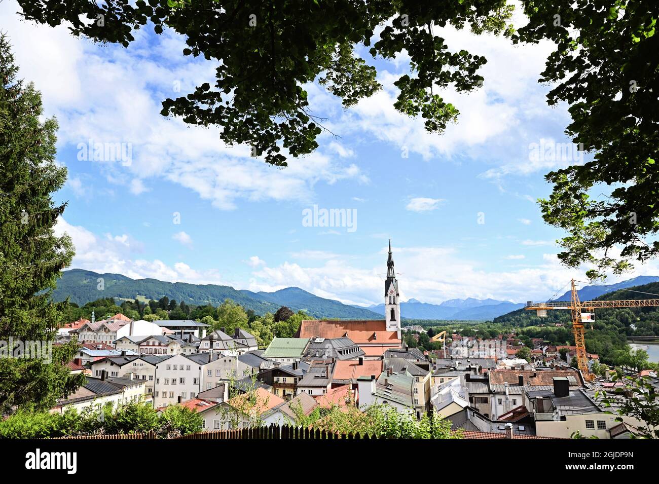 Vista di Bad Toelz, Oberbayern, incorniciata da alberi, con montagne sullo sfondo Foto Stock