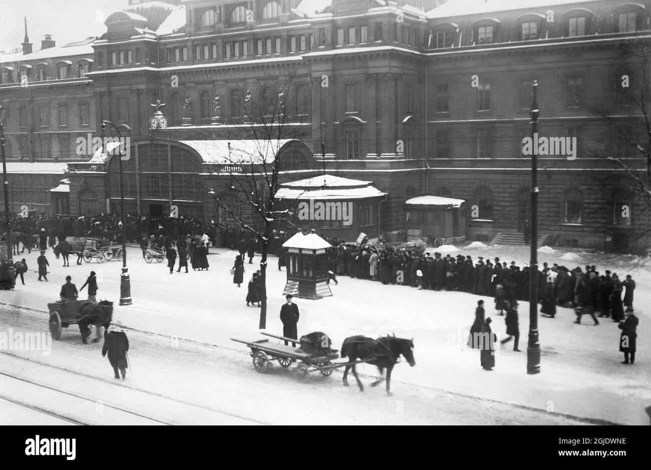 STOCKHOLM 1917-12 carretti trafilati a cavallo sulla strada e una lunga coda fuori dalla stazione centrale di Stoccolma con persone in attesa di acquistare i biglietti per le loro prossime gite di Natale. Foto: Archivio Bonnier / TT / Codice: 3001 richiesto da Mark Vivian Foto Stock