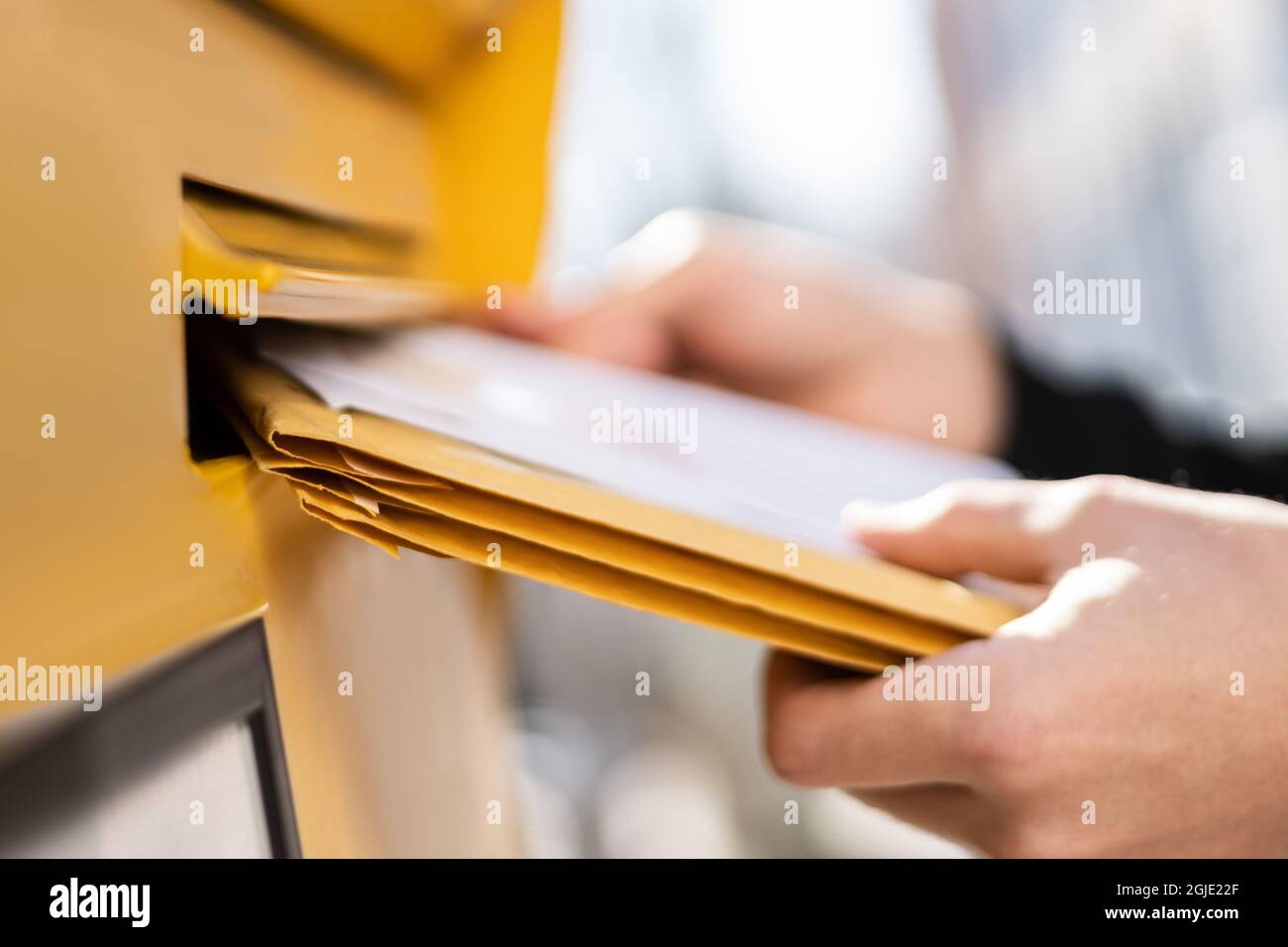 Recapito della posta della busta nella casella postale. Postman che mette lettera Foto Stock