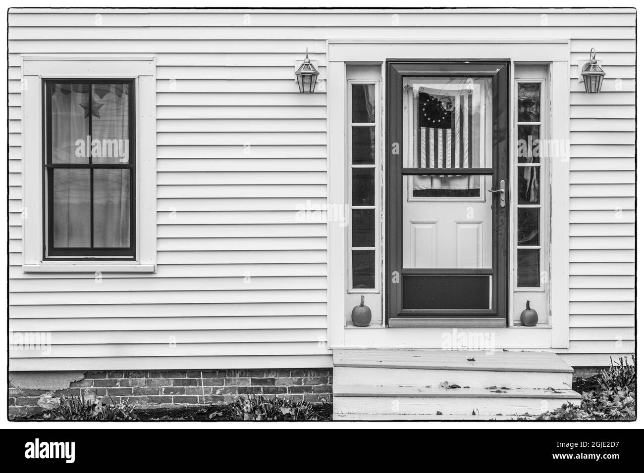 USA, Maine, Wiscasset. Dettagli della casa con bandiera degli Stati Uniti in autunno. Foto Stock