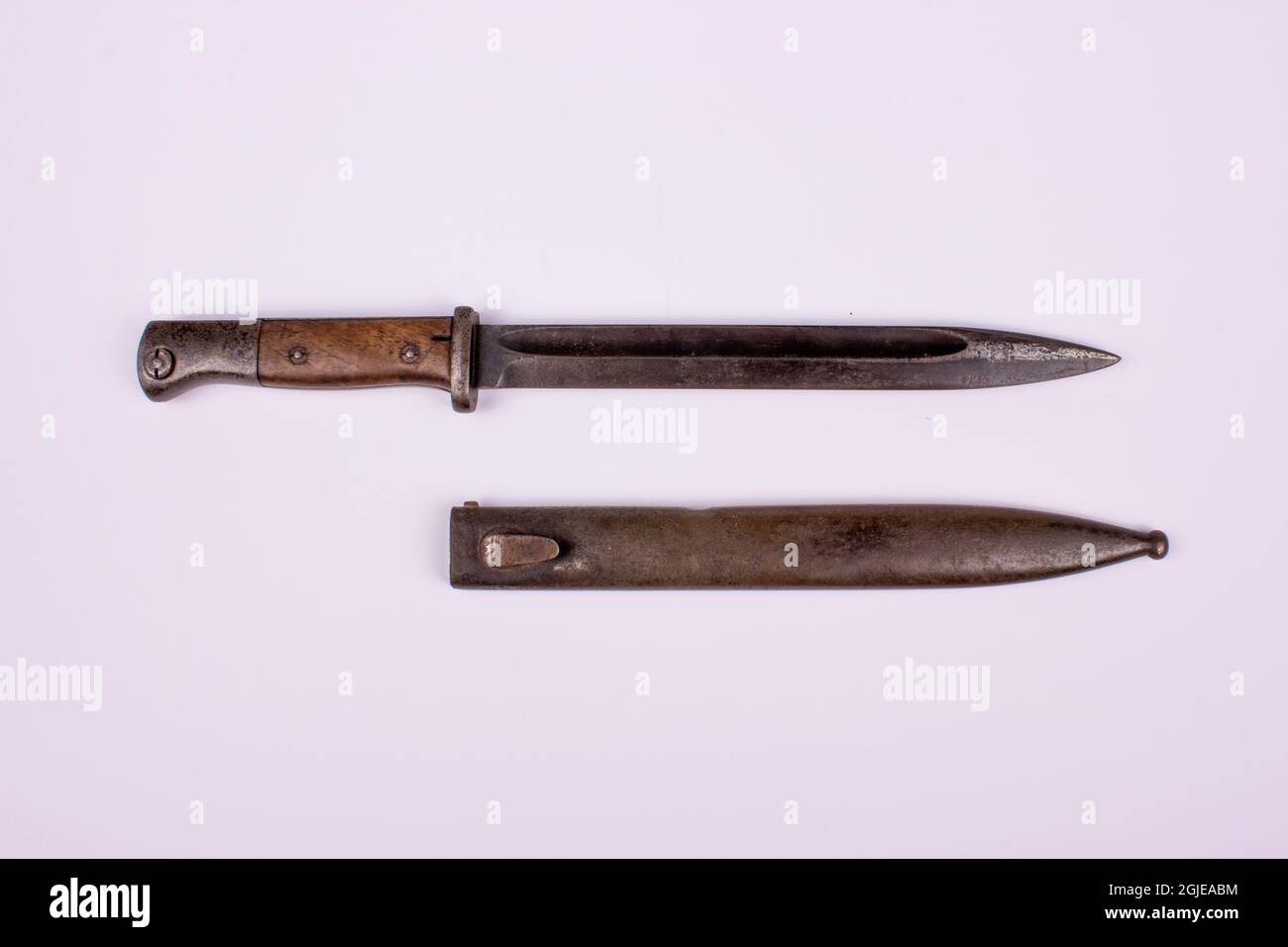Vecchio coltello tradizionale con la sua custodia in metallo sulla superficie bianca Foto Stock