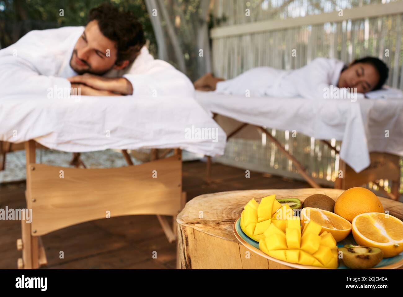 Coppia sdraiata sui tavoli da massaggio mentre si svolge il day-spa e un romantico weekend con frutta esotica presso il resort spa. massaggio per coppia Foto Stock