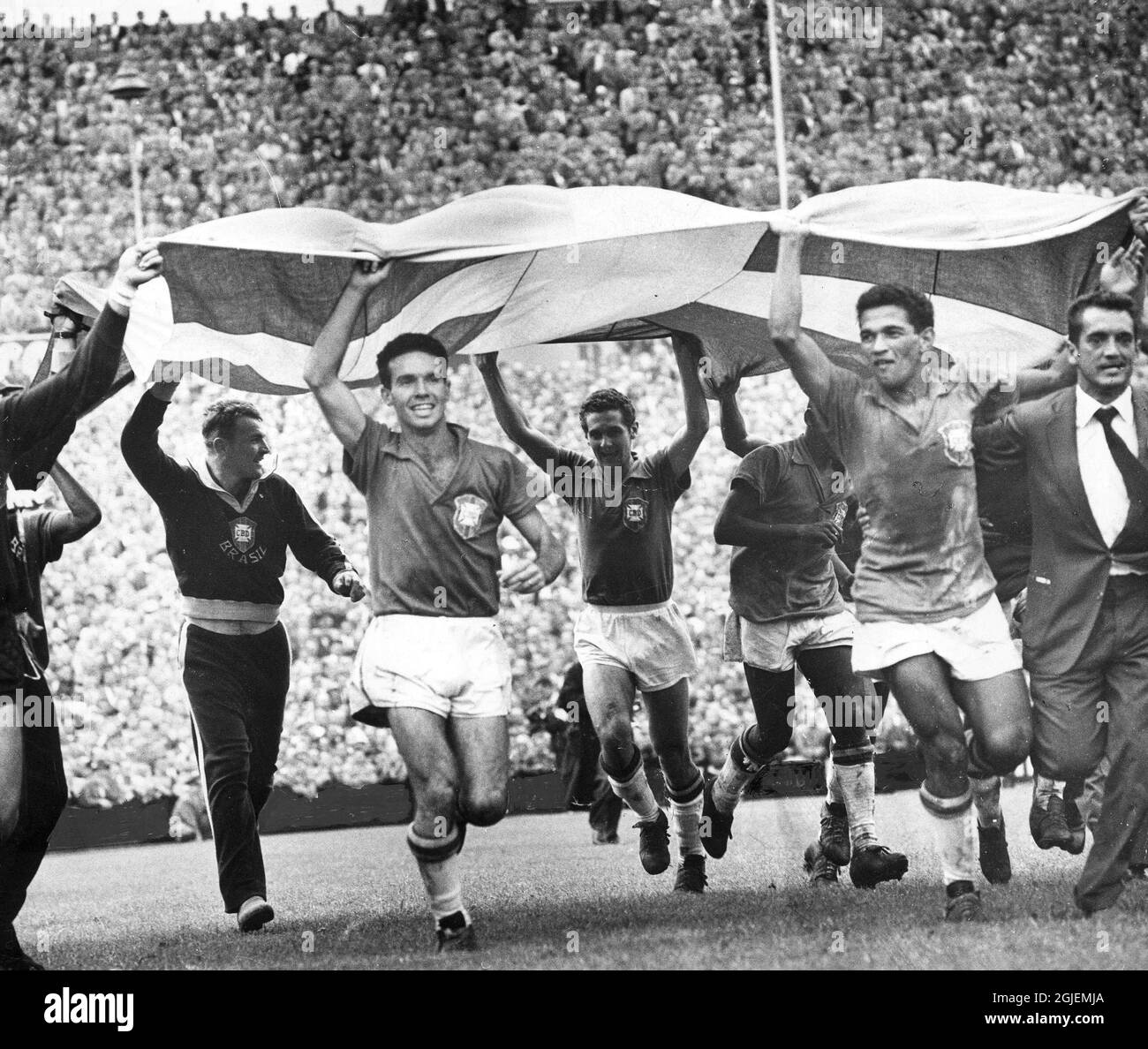 La finale di calcio della Coppa del mondo FIFA 1958 tra Svezia e Brasile si è tenuta allo stadio Rasunda, Svezia. Celebrazione brasiliana (con una bandiera svedese) dopo aver vinto la finale 5-2 e diventare campioni del mondo. Visto in primo piano al centro è Mario Zagallo (a sinistra) e Garrincha (a destra) Foto Stock