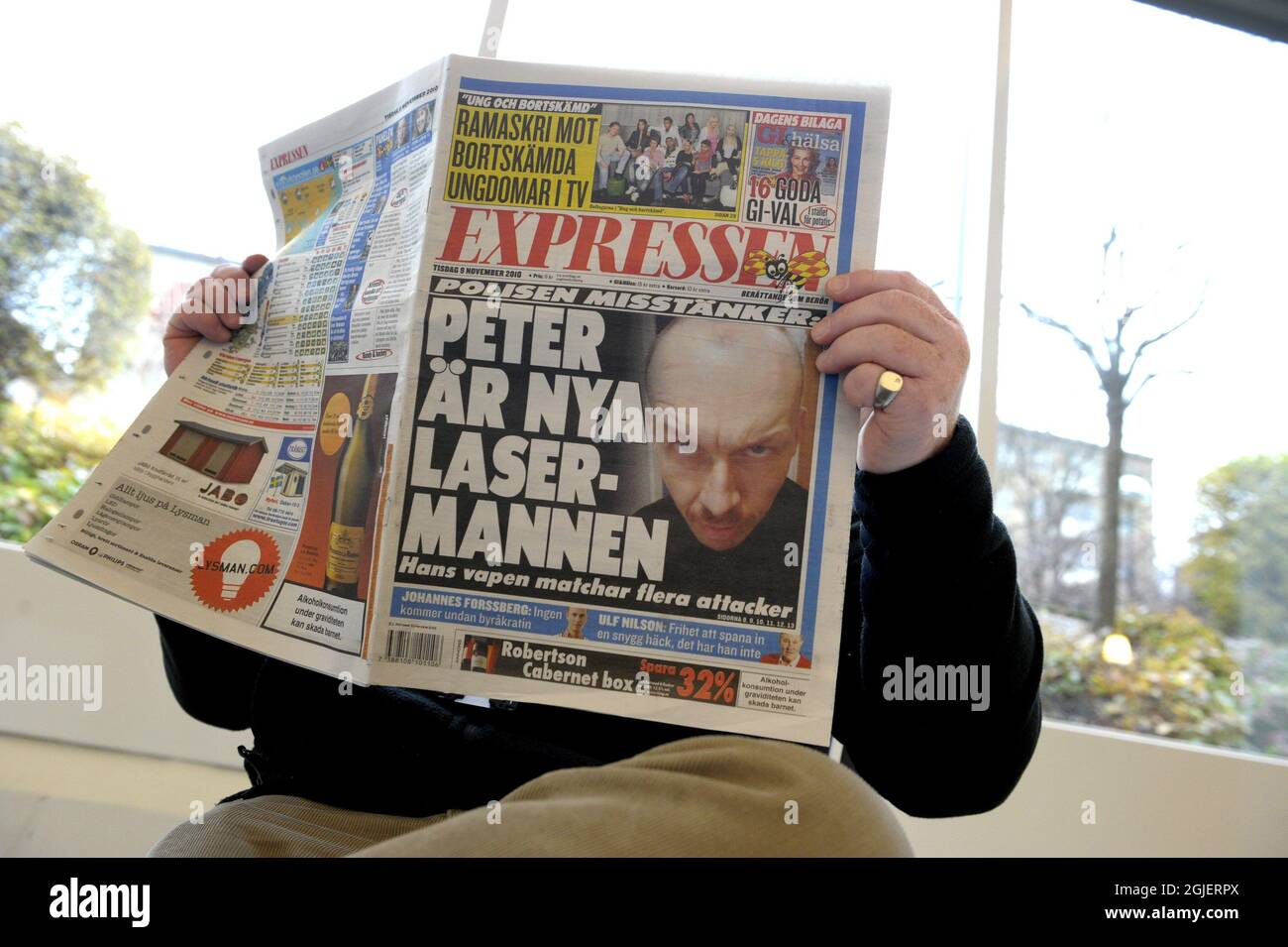 Un uomo è visto leggere il quotidiano svedese Expressen a Stoccolma, Svezia.  Il giornale ha pubblicato oggi il nome e le immagini dell'uomo sospettato  di uccidere una donna e ferire molte altre