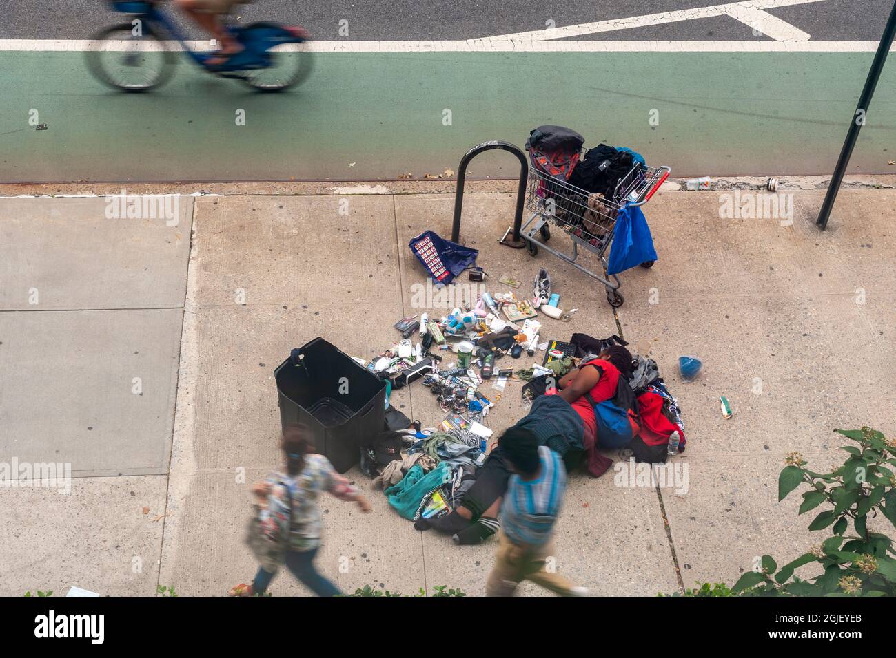 L'individuo senza tetto dorme nel mezzo del marciapiede a Chelsea a New York con i suoi possedimenti sparsi circa, visto la domenica 29 agosto 2021. (© Richard B. Levine) Foto Stock