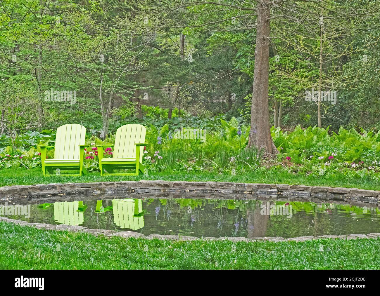 USA, Pennsylvania, Wayne e Chanticleer Gardens con laghetto e sedie verdi Foto Stock